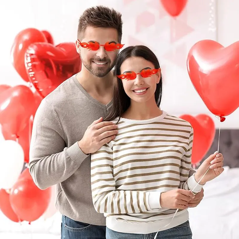 A Man And Woman Wearing Red Glasses And Holding Red Balloons